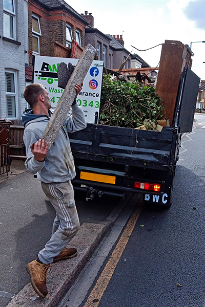 Member of the team placing construction waste in the truck.