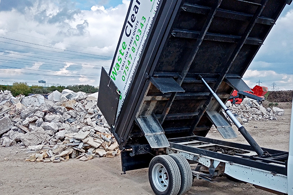 Unload waste from the truck at a commercial waste dump.